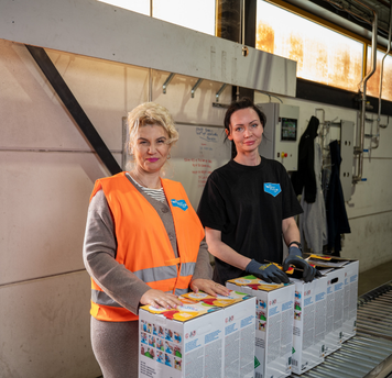 Twee verkoopmedewerkers controleren producten in een logistieke omgeving.