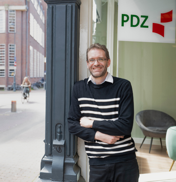 Technisch professional staat glimlachend voor vestiging van PDZ Uitzendbureau.