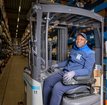 Heftruckchauffeur aan het werk in een magazijn.