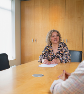 Management assistent voert een gesprek aan de vergadertafel.