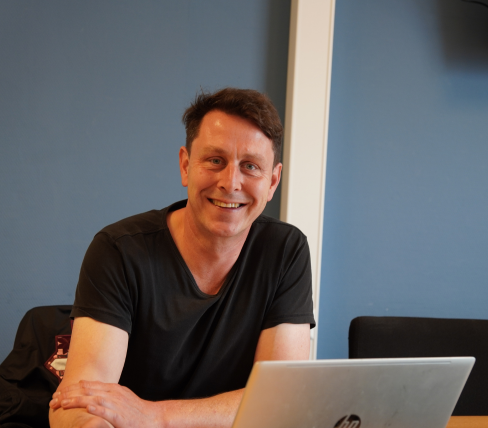 Bas aan het werk als woonbegeleider achter laptop.