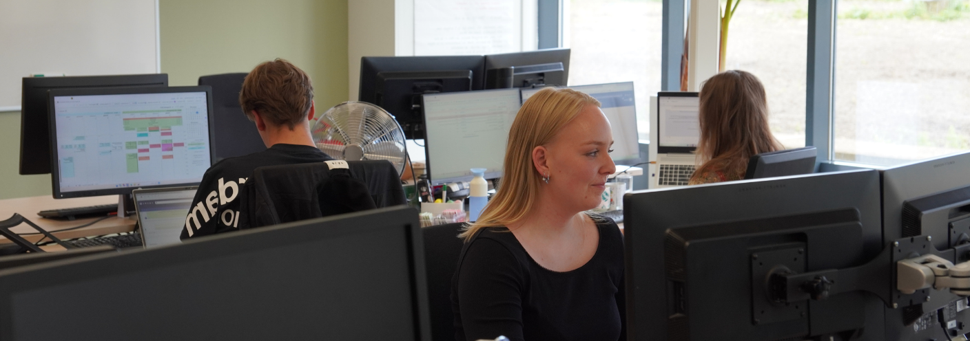 Logistiek administratief medewerker werkt achter computer op kantoor.