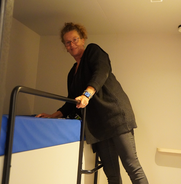 Woonbegeleider maakt een bed op in een slaapcabine binnen de opvanglocatie