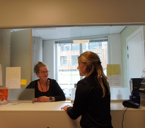 Annemiek is als woonbegeleider in gesprek met een collega