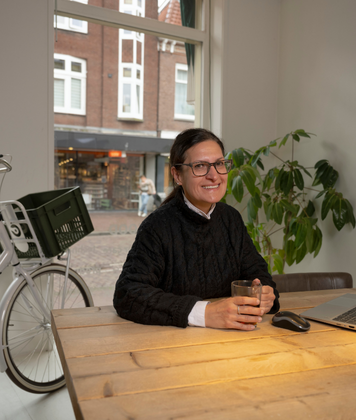 Administratief medewerker zit aan bureau met laptop in een rustige werkruimte.