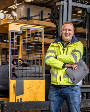 Teamleider logistiek bij heftruck in magazijnomgeving.