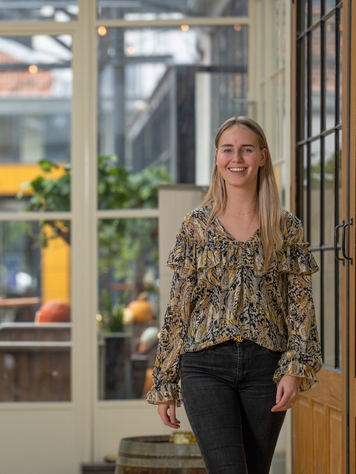 Financieel administratief medewerker loopt door een kantooromgeving.