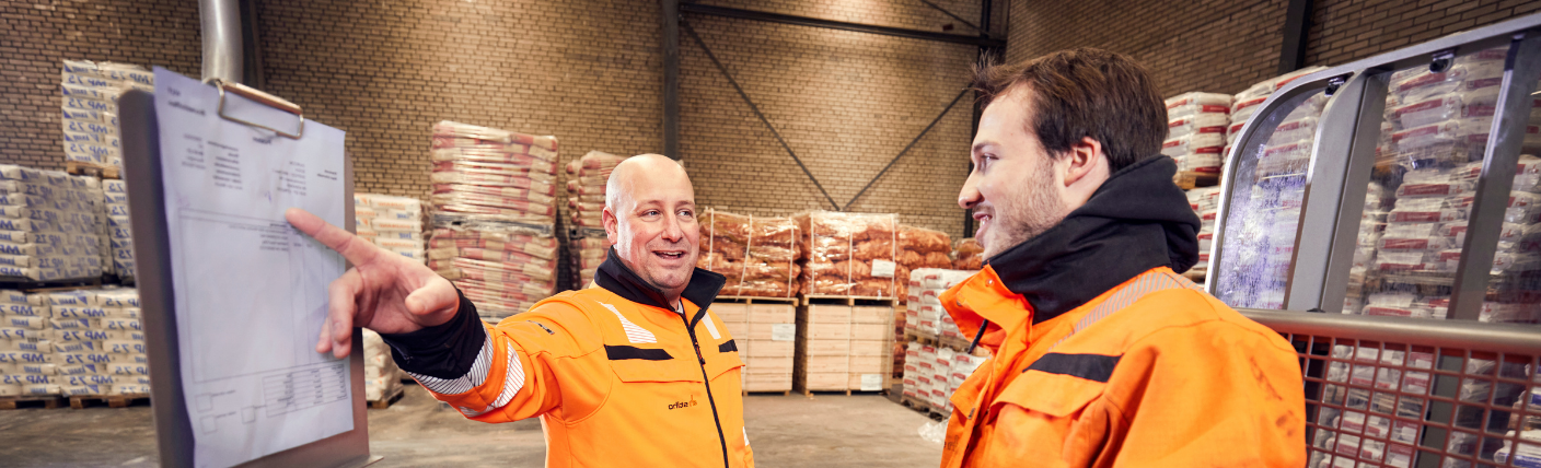 Twee logistiek teamleiders bespreken werkplanning in het magazijn.