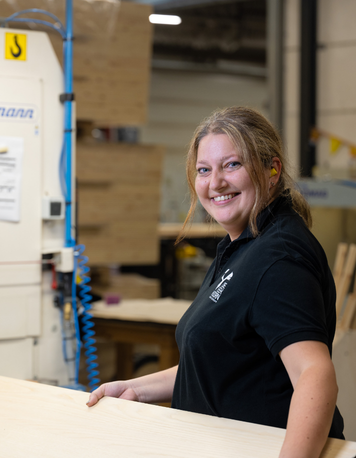 Operator werkt lachend met houten platen in een houtbewerkingsbedrijf