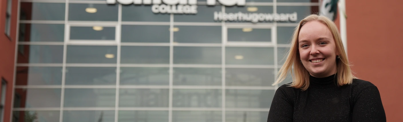 Commercieel medewerker staat voor een kantoorgebouw.